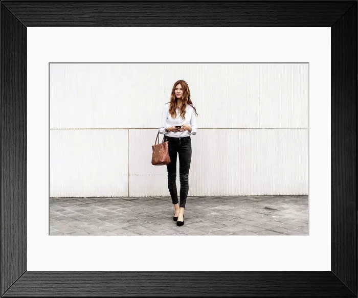 Framed Print : Young businesswoman commuting in the city, using smartphone