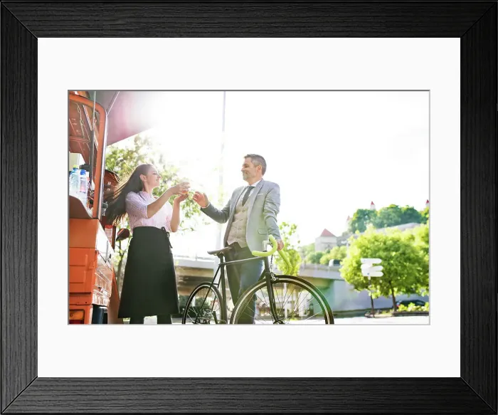Framed Print : Businessman with bicycle buying take away coffee on the street