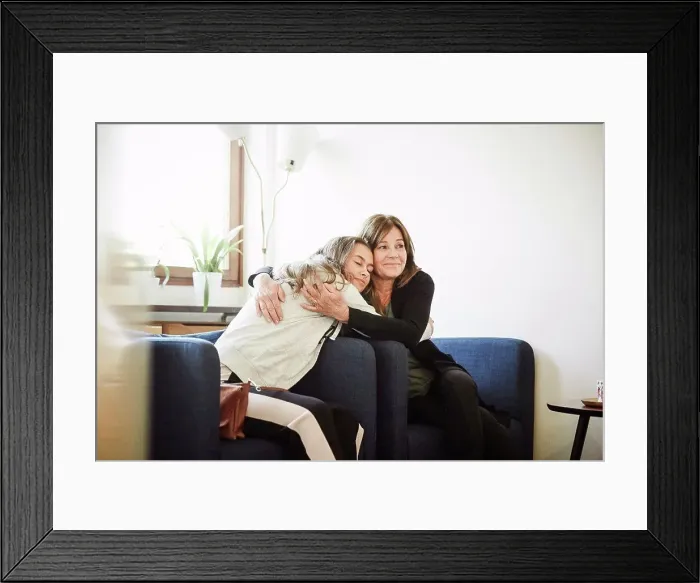 Framed Print : Mother and daughter embracing while sitting at wellness center Framed Print : Mother and daughter embracing while sitting at wellness center