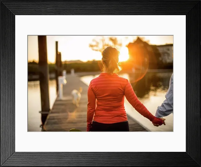 Framed Print : Couple walking hand in hand along a pier at sunset Framed Print : Couple walking hand in hand along a pier at sunset