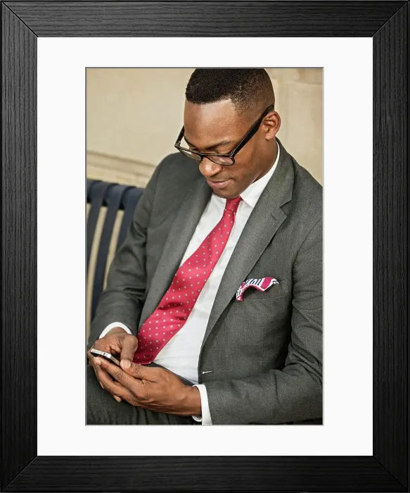 Framed Print : Black businessman using cell phone on bench Framed Print : Black businessman using cell phone on bench