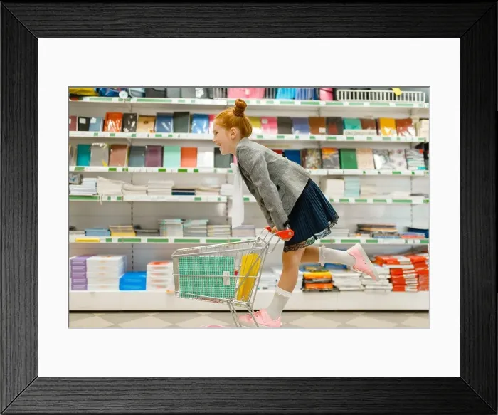 Framed Print : Little schoolgirl with a cart at the shelf Framed Print : Little schoolgirl with a cart at the shelf