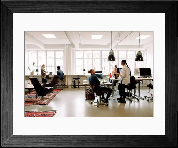 Framed Print : Male and female business colleagues working in creative workplace