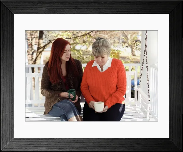 Framed Print : Senior woman and adult daughter having serious discussion on porch