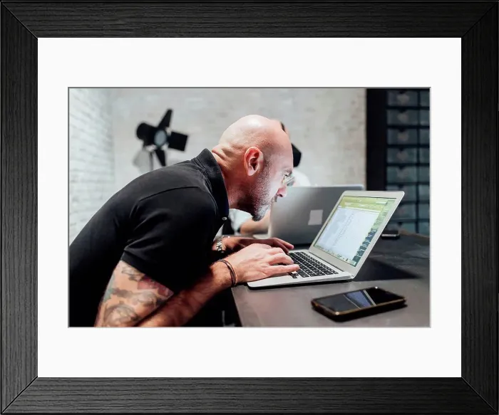 Framed Print : Man using laptop, peering Framed Print : Man using laptop, peering