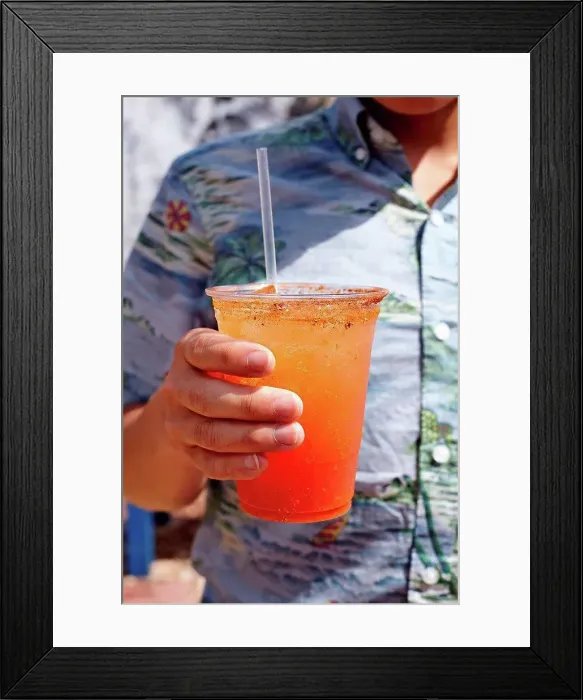 Framed Print : Young man holding michelada cocktail, mid section, close-up Framed Print : Young man holding michelada cocktail, mid section, close-up