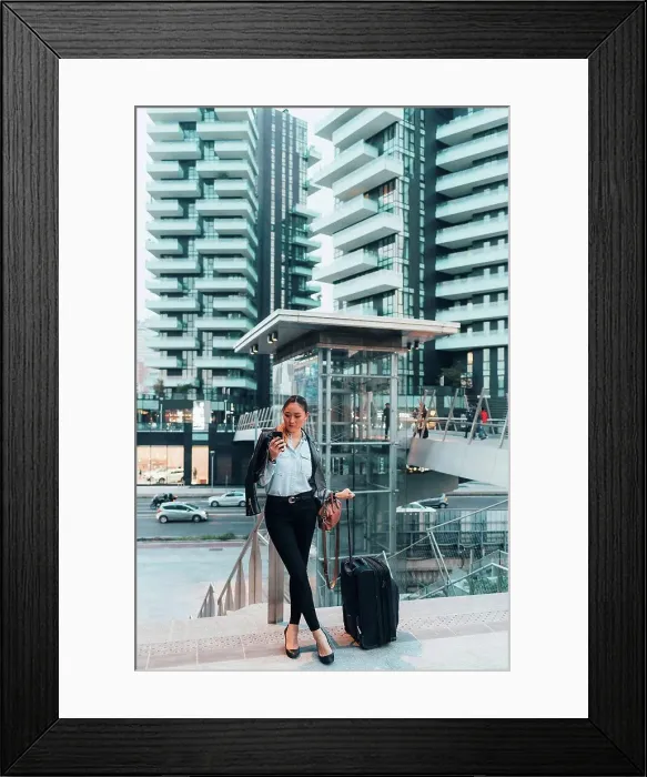 Framed Print : Businesswoman, outdoors, holding wheeled suitcase, using smartphone Framed Print : Businesswoman, outdoors, holding wheeled suitcase, using smartphone