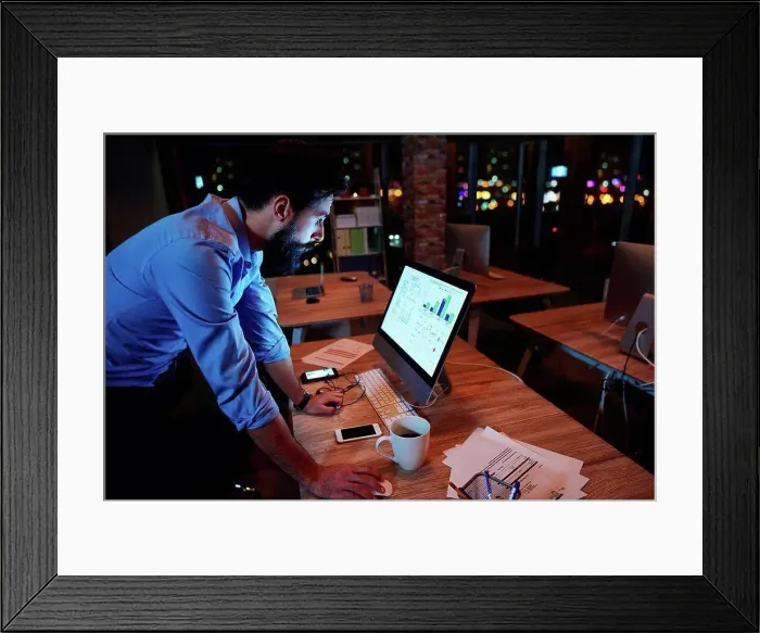 Framed Print : Young businessman working at computer on office desk at night Framed Print : Young businessman working at computer on office desk at night