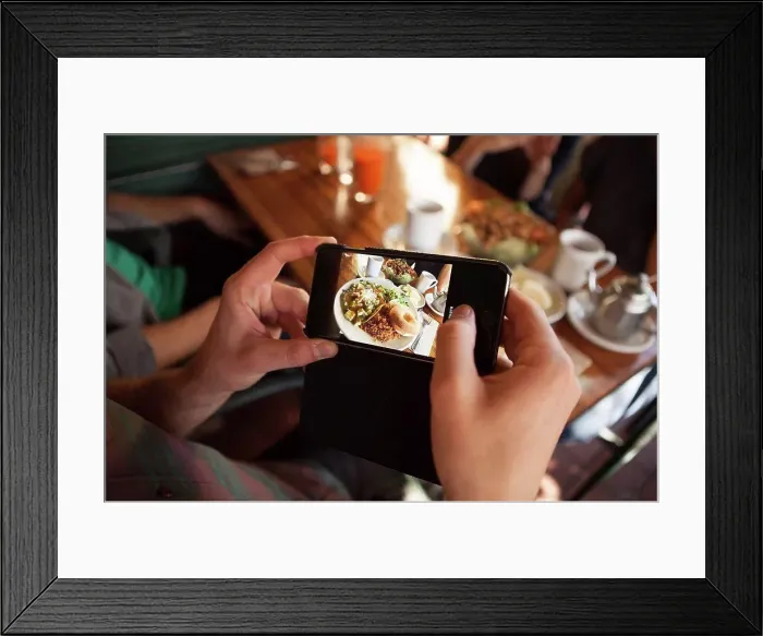 Framed Print : Cropped shot of man taking photograph of meal in vegetarian restaurant Framed Print : Cropped shot of man taking photograph of meal in vegetarian restaurant