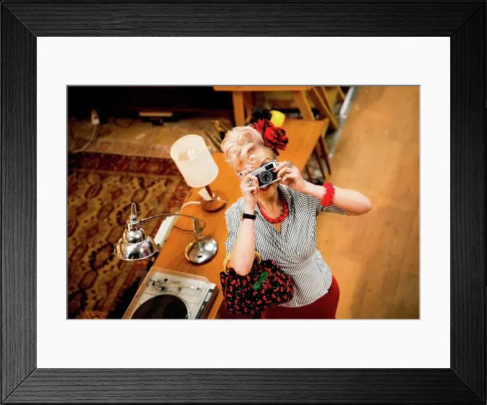 Framed Print : Quirky woman taking photographs on vintage camera in antiques emporium