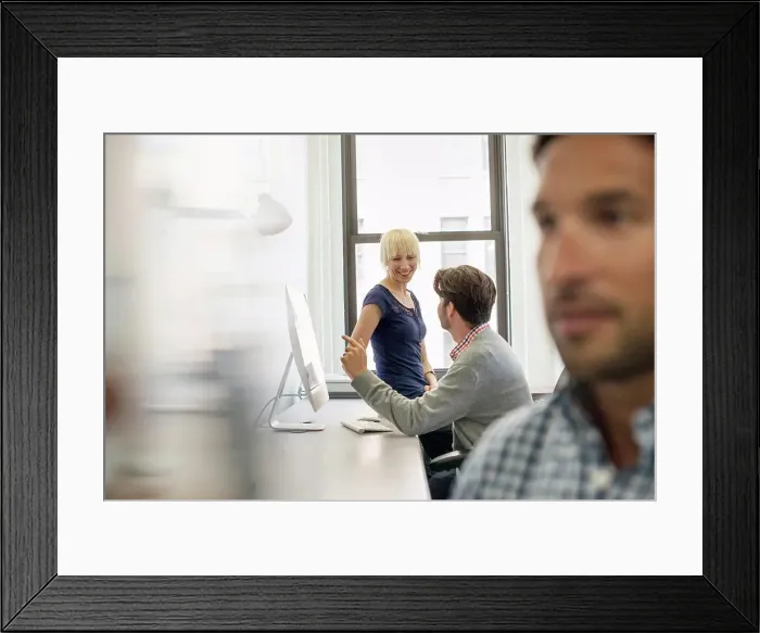 Framed Print : Three business colleagues in an office, two talking and one standing by the door listening Framed Print : Three business colleagues in an office, two talking and one standing by the door listening