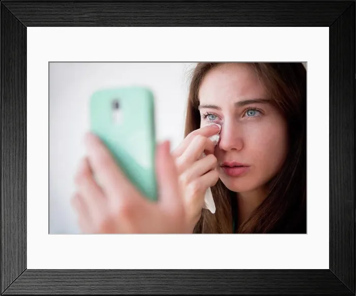 Framed Print : Native American woman with cell phone wiping away tears Framed Print : Native American woman with cell phone wiping away tears