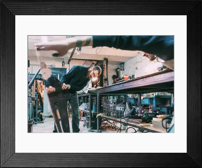 Framed Print : Metalworkers inspecting sheet copper in forge workshop