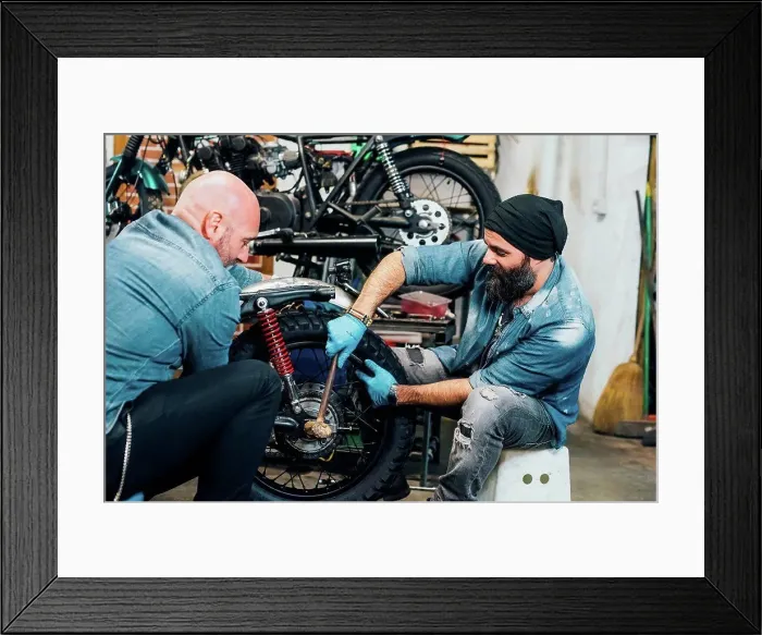 Framed Print : Two mature men, working on motorcycle in garage