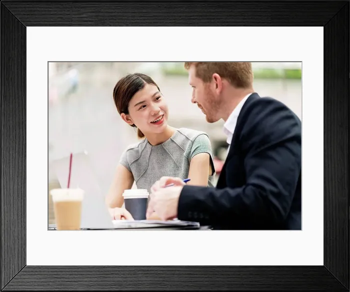 Framed Print : Young businessman and woman having discussion at sidewalk cafe Framed Print : Young businessman and woman having discussion at sidewalk cafe