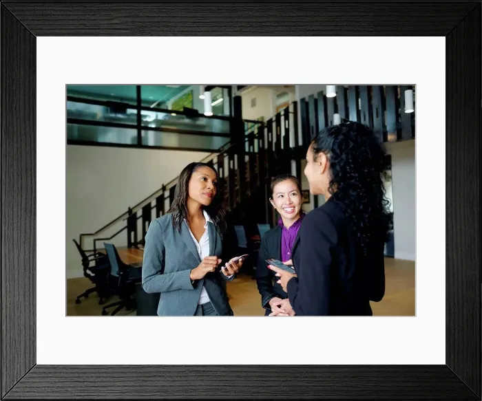 Framed Print : Three businesswomen standing in office, in conversation Framed Print : Three businesswomen standing in office, in conversation