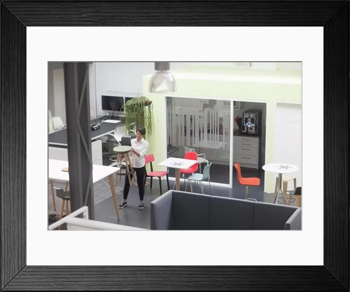 Framed Print : Young female sales manager inspecting office stool in office furniture store
