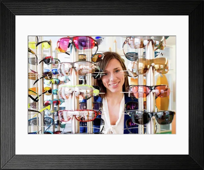Framed Print : View through eyeglasses display of woman looking at camera smiling Framed Print : View through eyeglasses display of woman looking at camera smiling