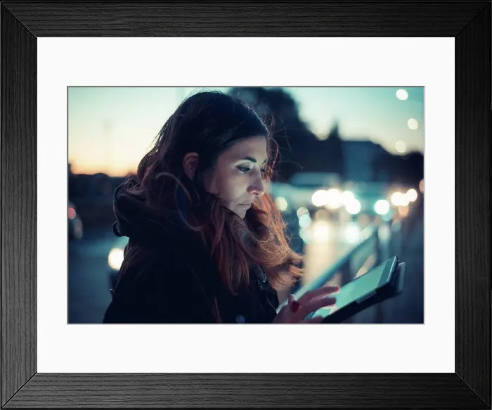 Framed Print : Mid adult woman using digital tablet touchscreen on street at dusk Framed Print : Mid adult woman using digital tablet touchscreen on street at dusk