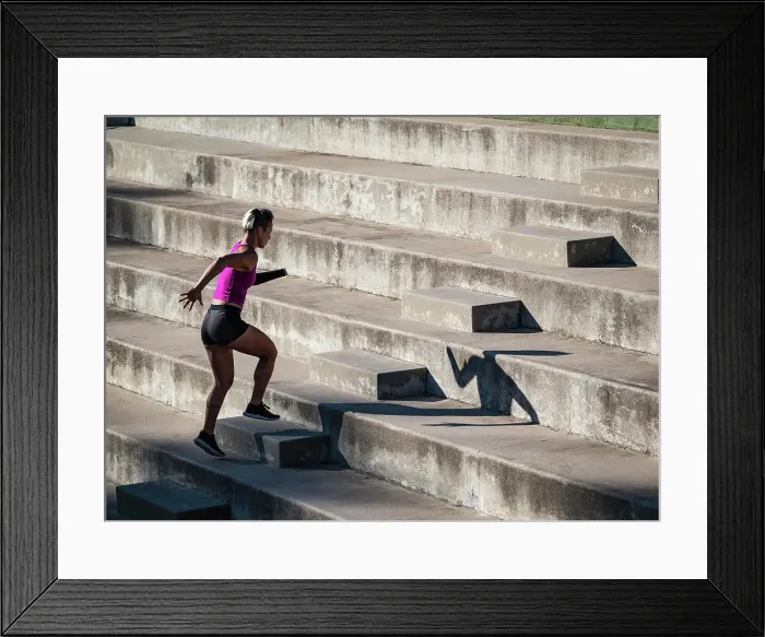 Framed Print : Woman with amputated hand jogging up steps