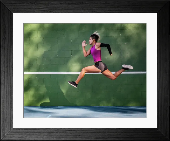 Framed Print : Athletic woman with prosthetic arm running against wall Framed Print : Athletic woman with prosthetic arm running against wall
