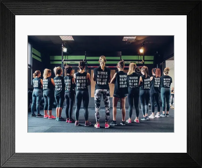 Framed Print : Group of women training in gym, wearing slogan t-shirts, rear view