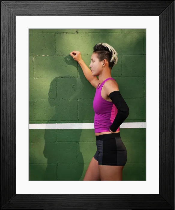Framed Print : Athletic woman with amputated hand leaning against wall Framed Print : Athletic woman with amputated hand leaning against wall