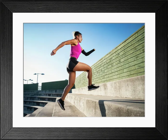 Framed Print : Athletic woman with amputated hand running up steps Framed Print : Athletic woman with amputated hand running up steps