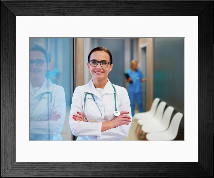 Framed Print : Portrait of doctor in hallway, arms folded, smiling