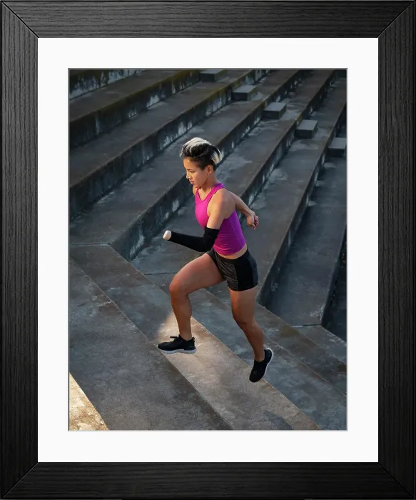 Framed Print : Athletic woman with amputated hand running up steps Framed Print : Athletic woman with amputated hand running up steps