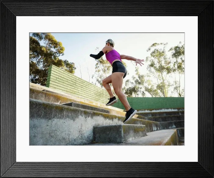 Framed Print : Athletic woman with amputated hand running up steps