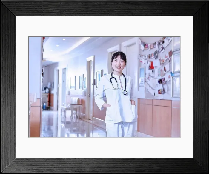 Framed Print : Portrait of doctor in hospital corridor looking at camera smiling