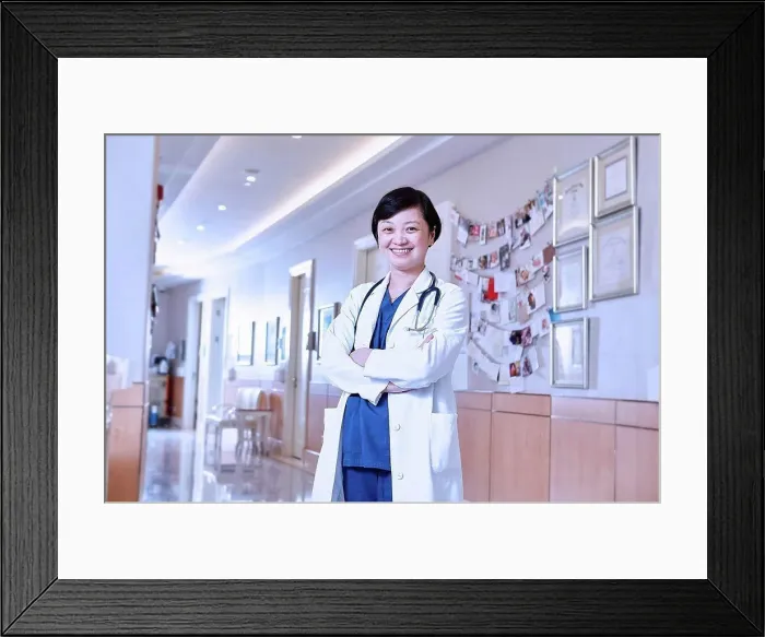 Framed Print : Portrait of doctor in hospital corridor looking at camera smiling