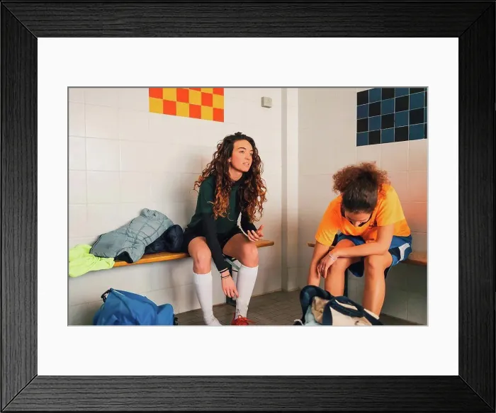 Framed Print : Football players on bench in changing room