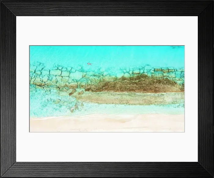 Framed Print : Aerial view of woman floating on the crystal sea in between coral reef and white sand beach Framed Print : Aerial view of woman floating on the crystal sea in between coral reef and white sand beach