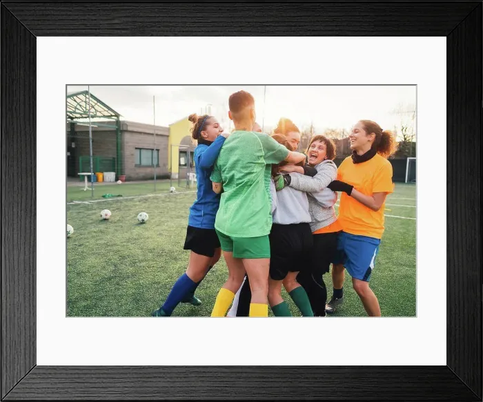 Framed Print : Football players jubilant and hugging on pitch