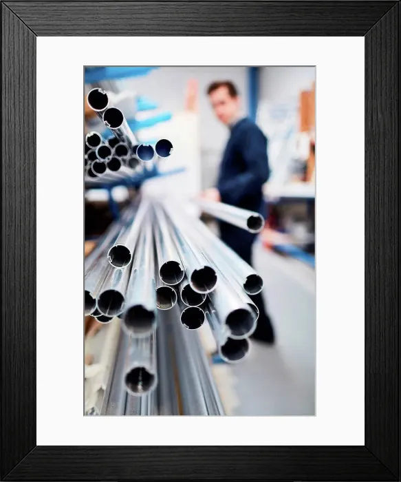 Framed Print : Factory worker removing metal rod from shelf in roller blind factory Framed Print : Factory worker removing metal rod from shelf in roller blind factory