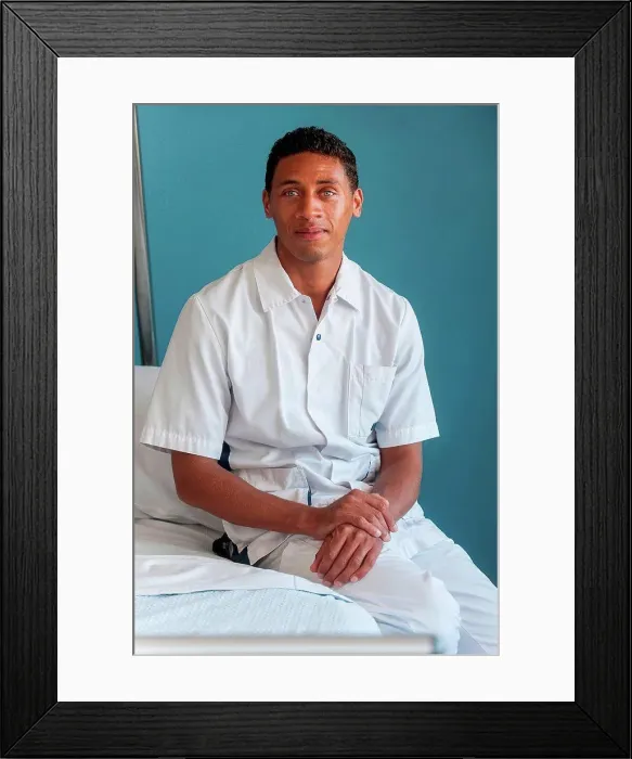 Framed Print : Portrait of nurse sitting on hospital bed Framed Print : Portrait of nurse sitting on hospital bed