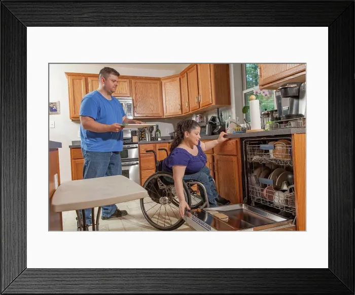 Framed Print : Woman with Spina Bifida and her husband using the dishwasher in kitchen Framed Print : Woman with Spina Bifida and her husband using the dishwasher in kitchen