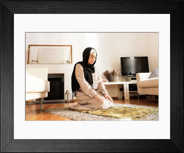 Framed Print : Young muslim woman kneeling on mat for prayer Framed Print : Young muslim woman kneeling on mat for prayer