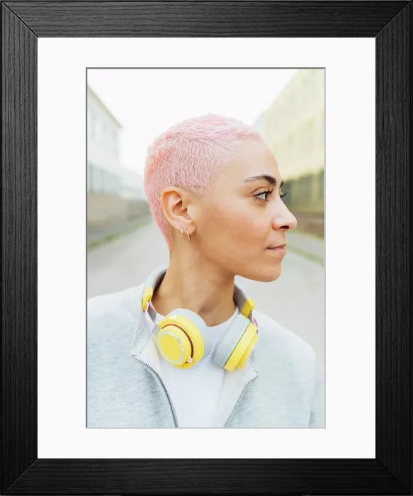 Framed Print : Portrait of young woman with short pink hair, wearing headphones Framed Print : Portrait of young woman with short pink hair, wearing headphones