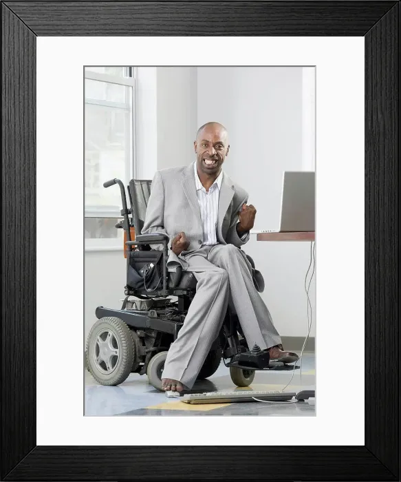 Framed Print : Businessman with Cerebral Palsy working on a computer with his foot Framed Print : Businessman with Cerebral Palsy working on a computer with his foot
