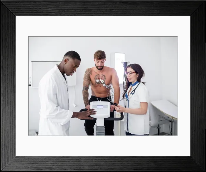 Framed Print : Doctor and nurse performing ECG test on patient in consultation room