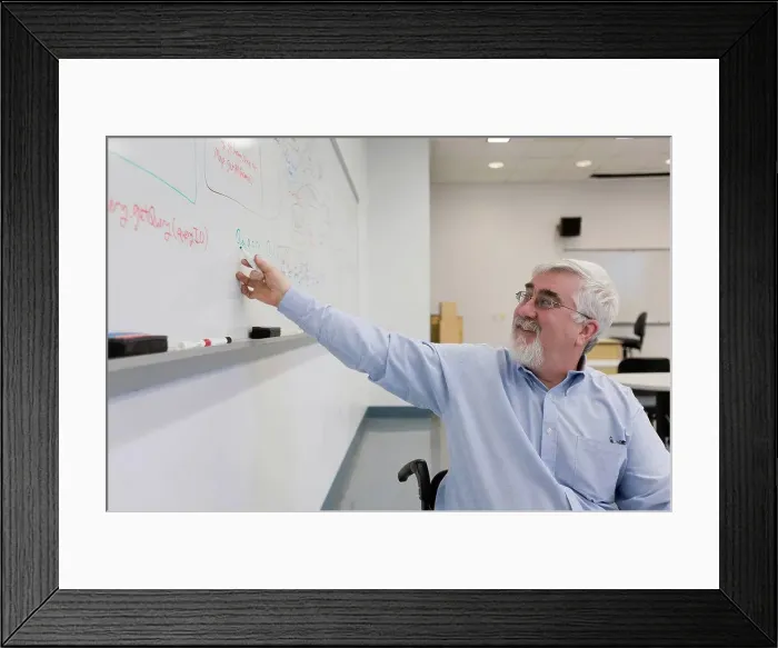 Framed Print : University professor with Muscular Dystrophy writing on a whiteboard in a classroom Framed Print : University professor with Muscular Dystrophy writing on a whiteboard in a classroom