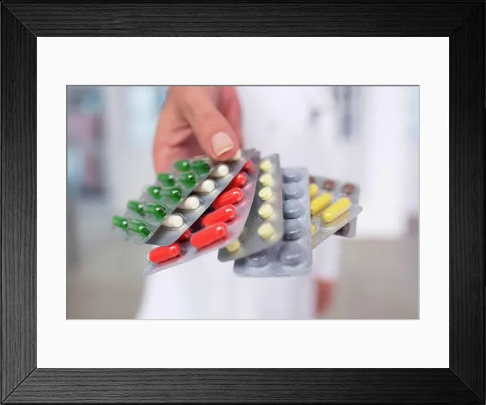 Framed Print : Cropped view of doctor holding pills in blister packs Framed Print : Cropped view of doctor holding pills in blister packs