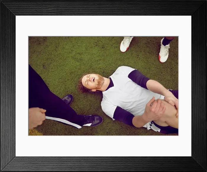 Framed Print : Injured male soccer player on soccer pitch Framed Print : Injured male soccer player on soccer pitch