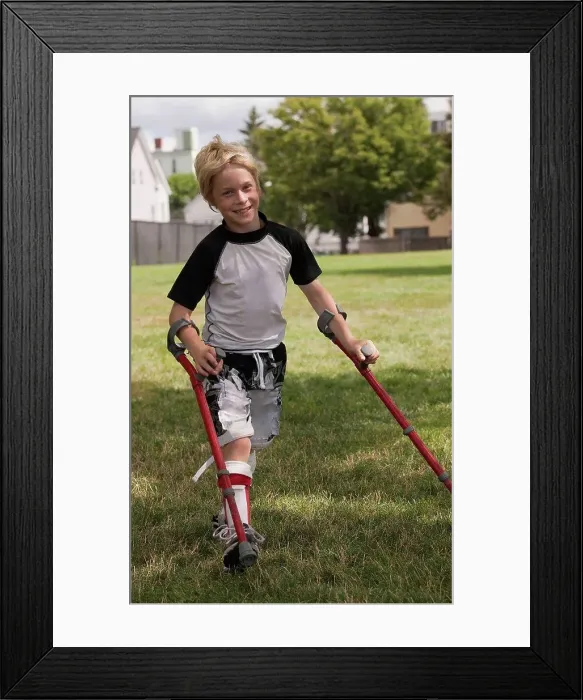 Framed Print : Boy with cerebral palsy walking with the support of crutches Framed Print : Boy with cerebral palsy walking with the support of crutches
