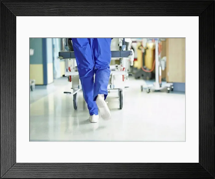 Framed Print : Legs of medic running with gurney along hospital corridor