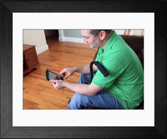 Framed Print : Man after anterior cruciate ligament (ACL) surgery with cane and using an digital tablet at home Framed Print : Man after anterior cruciate ligament (ACL) surgery with cane and using an digital tablet at home