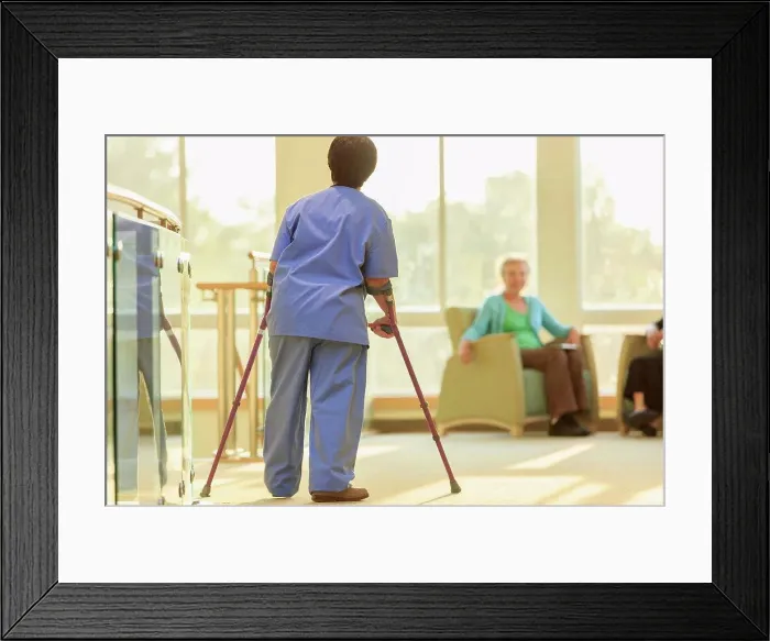 Framed Print : Nurse with Cerebral Palsy walking down the hallway of a clinic with her canes Framed Print : Nurse with Cerebral Palsy walking down the hallway of a clinic with her canes